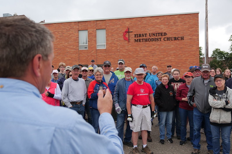 Man speaking to group of volunteers outside UMC Church