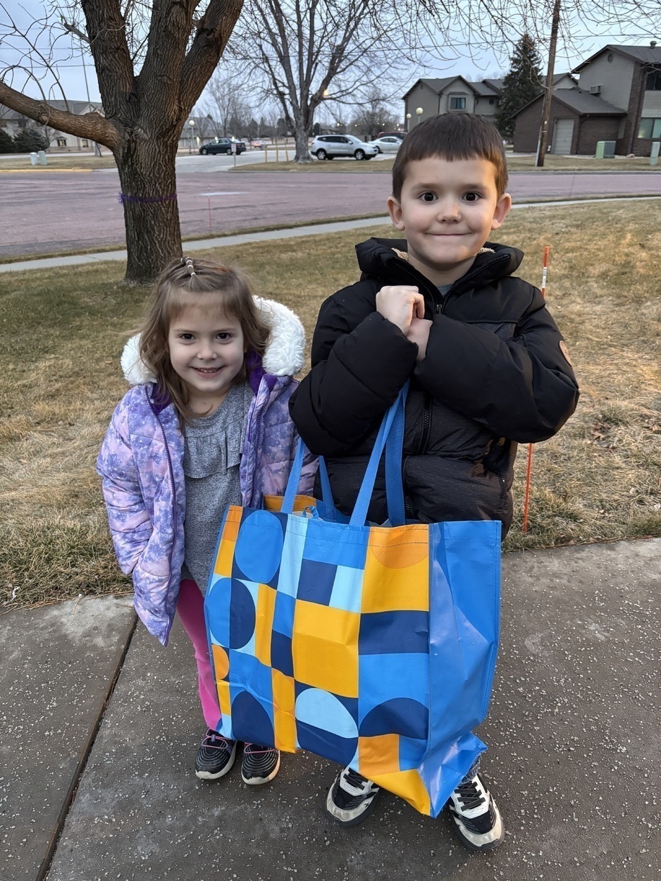 Two children outside with tote bag