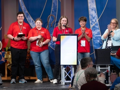 Group of youth in red shirts at podium