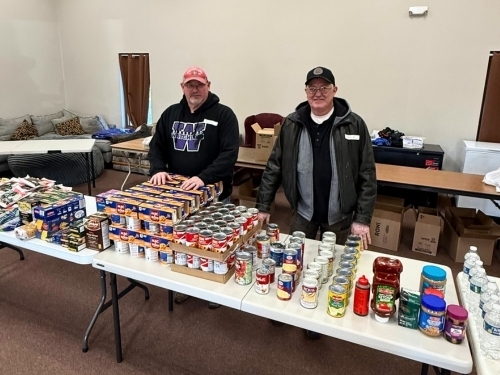 Volunteers behind table of commodities